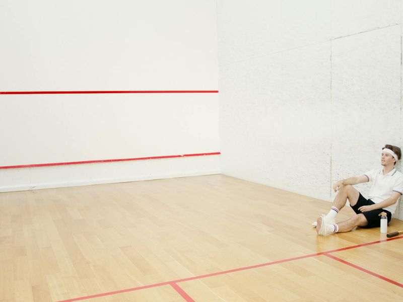 Man focused on a floor exercise in a spacious, well-lit room.